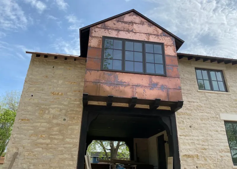 Copper metal panel facade on a stone building for Skylight Installation in Ligonier
